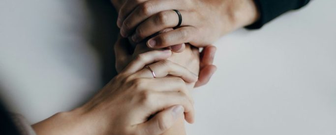 Two women holding hands ina supportive way during alcohol detox - Step By Step Recovery