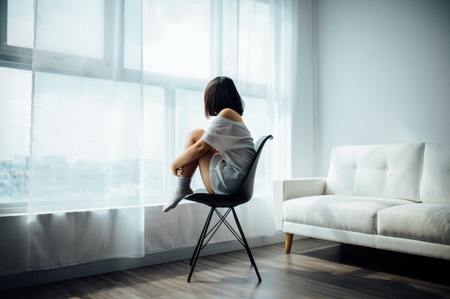 woman sitting in a chair facing a window